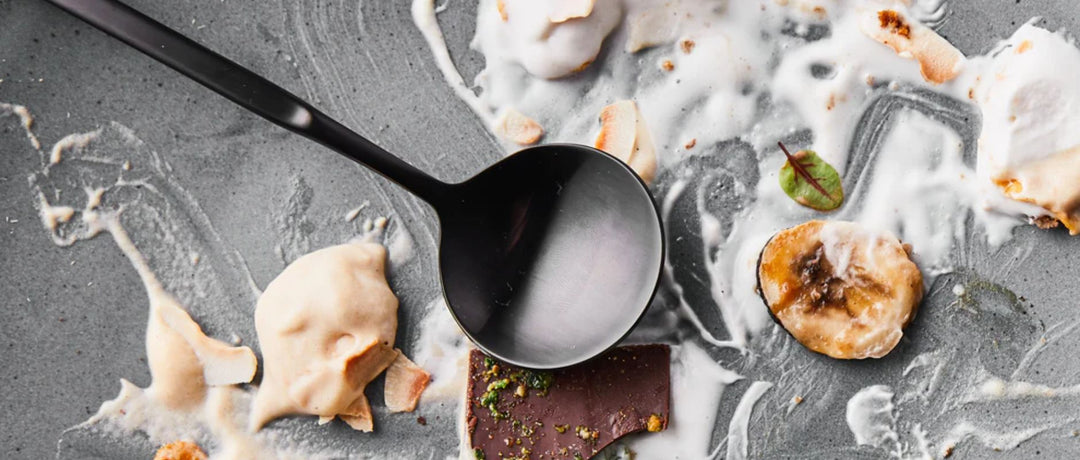 A banner for a blog post sharing the May 2023 playlist: Beats For Eats. The image features a KROF branded spoon in a matte black finish. It's on a plate that's been decoratively smeared with what's left of a delicious meal.