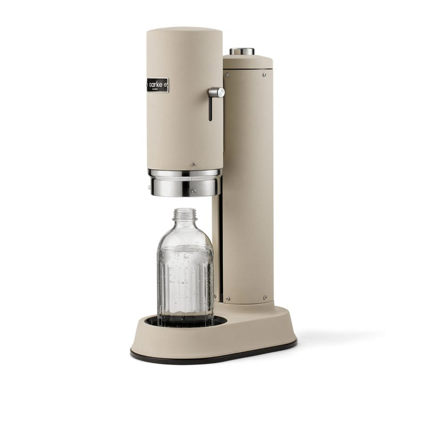 Studio lighting, perspective view of a cannister-shaped carbonator with a glass bottle filled with fizzy water