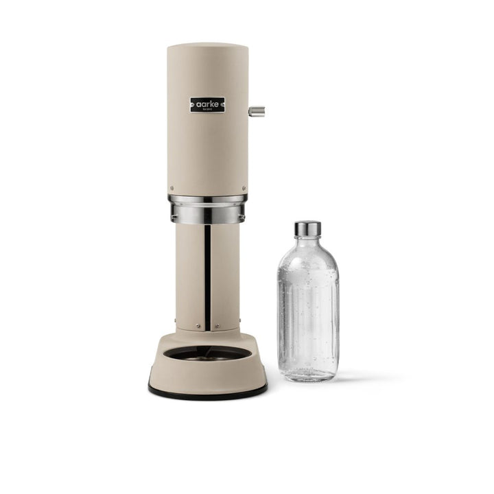 Studio lighting, perspective view of a cannister-shaped water carbonator placed next to a glass water bottle