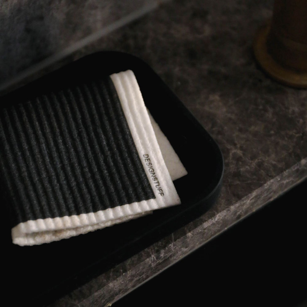 Folded black dishcloth in a sink