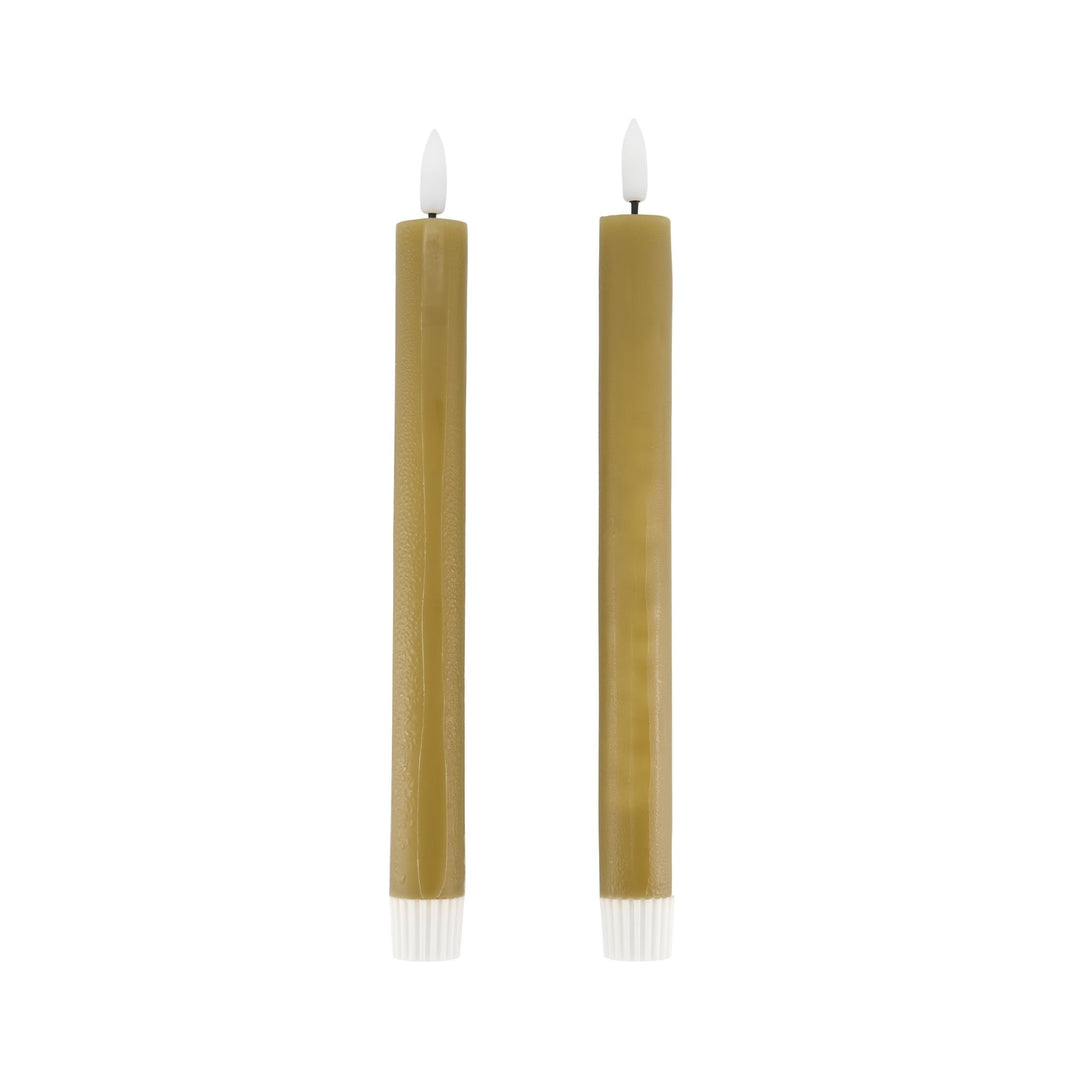 Two tall, thin candles with white wicks on a white background