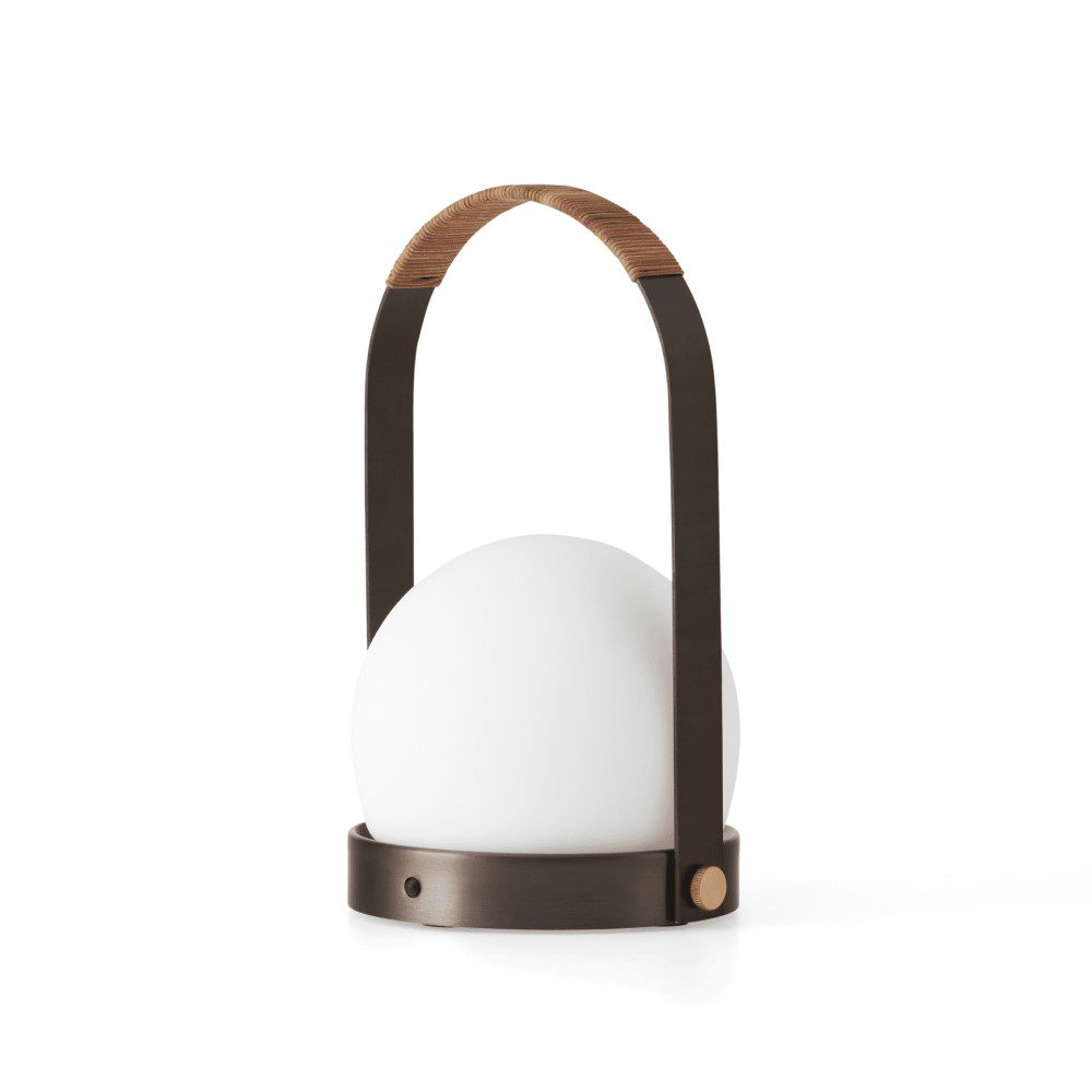 A portable hand-carry, round-shaped lamp with an arched handle.