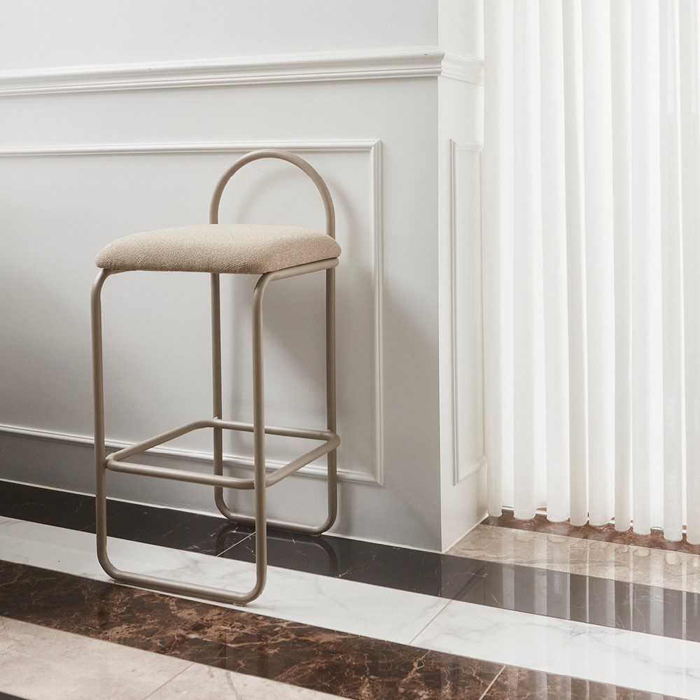 Natural lighting, perspective view of a stool backed against a wall