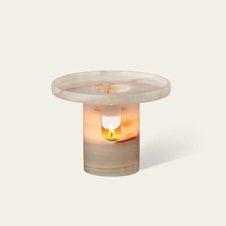 A cylinder-shaped oil diffuser with a round tray on top.