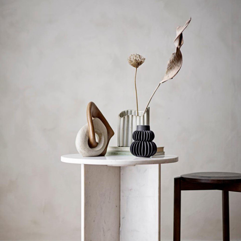 Natural lighting, perspective view of an abstract shaped vase on a table.