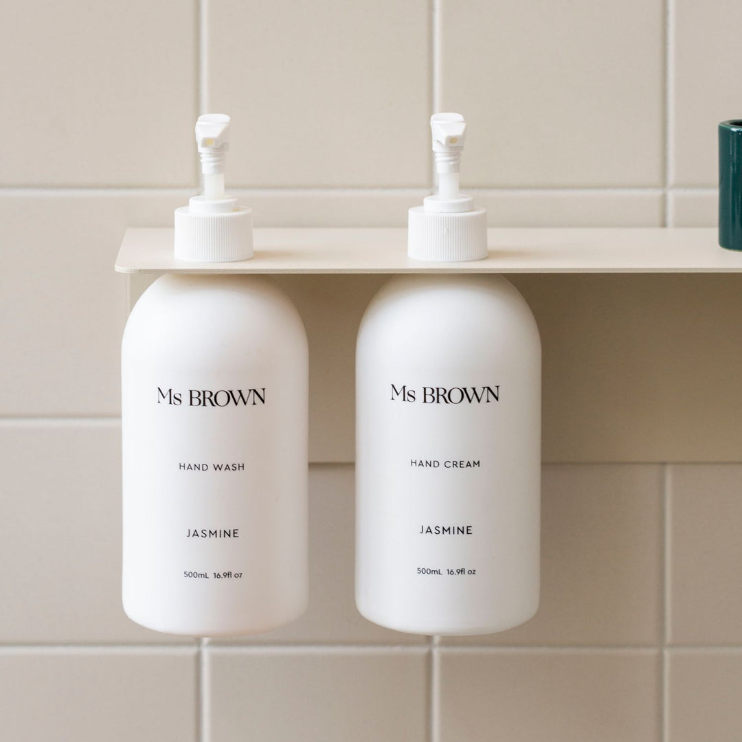 Sand DESIGNSTUFF Shelf with Dual Soap Dispenser Holder in a bathroom with white tiles