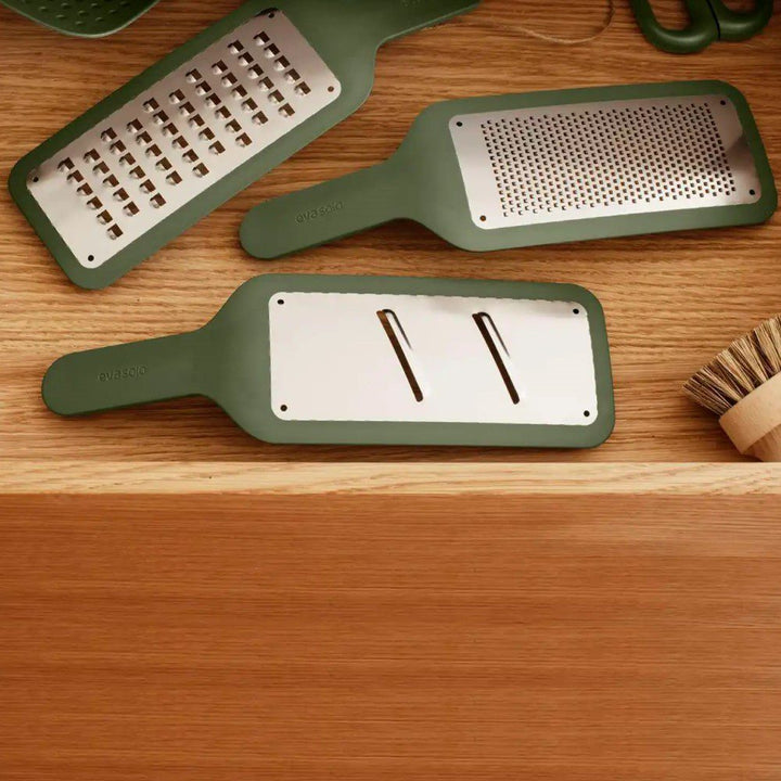 A variety of vegetable slicers placed side by side in a kitchen drawer.