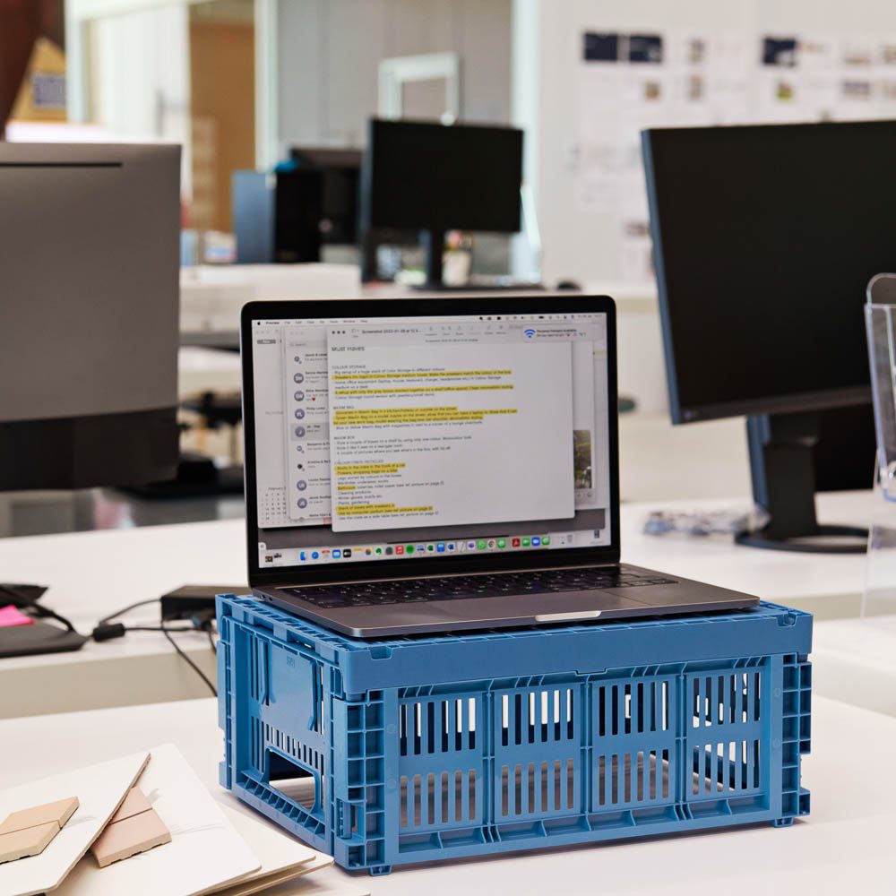 A laptop on a versatile colour crate storage box.