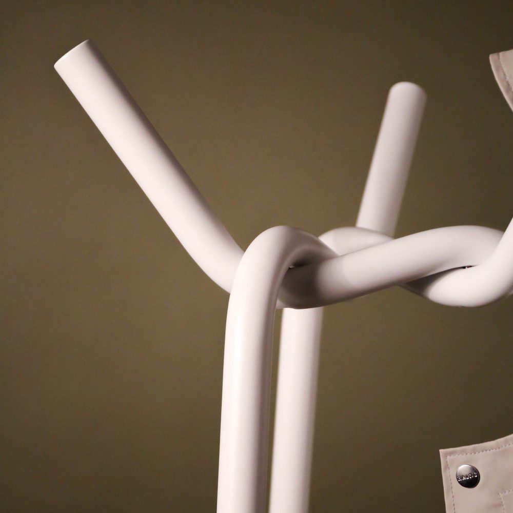 Close up of a steel coat rack in a twisted and knitted pattern.