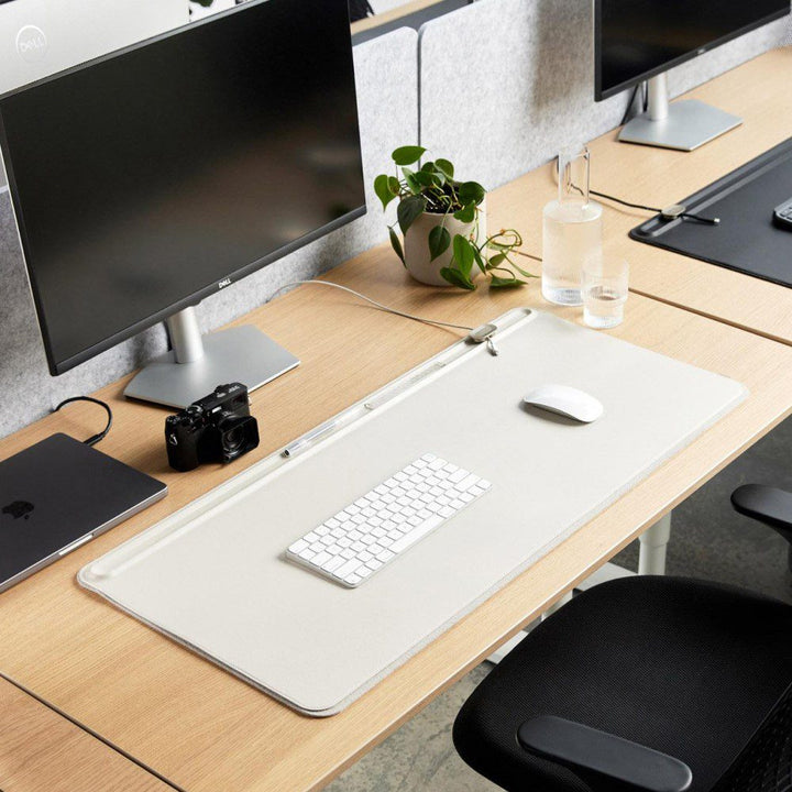 Natural light, perspective view of a rectangular shaped leather organiser with a keyboard and mouse, and placed on top of a wooden office desk.