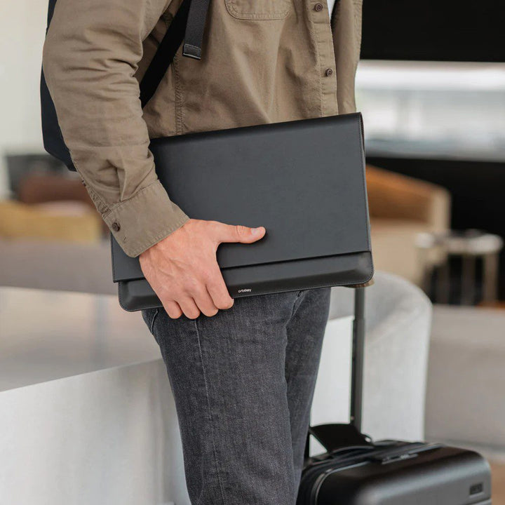 Natural light, perspective view of a person holding a laptop sleeve on its side.