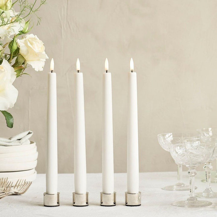 Rows of flameless, tapered candles standing next to each other.