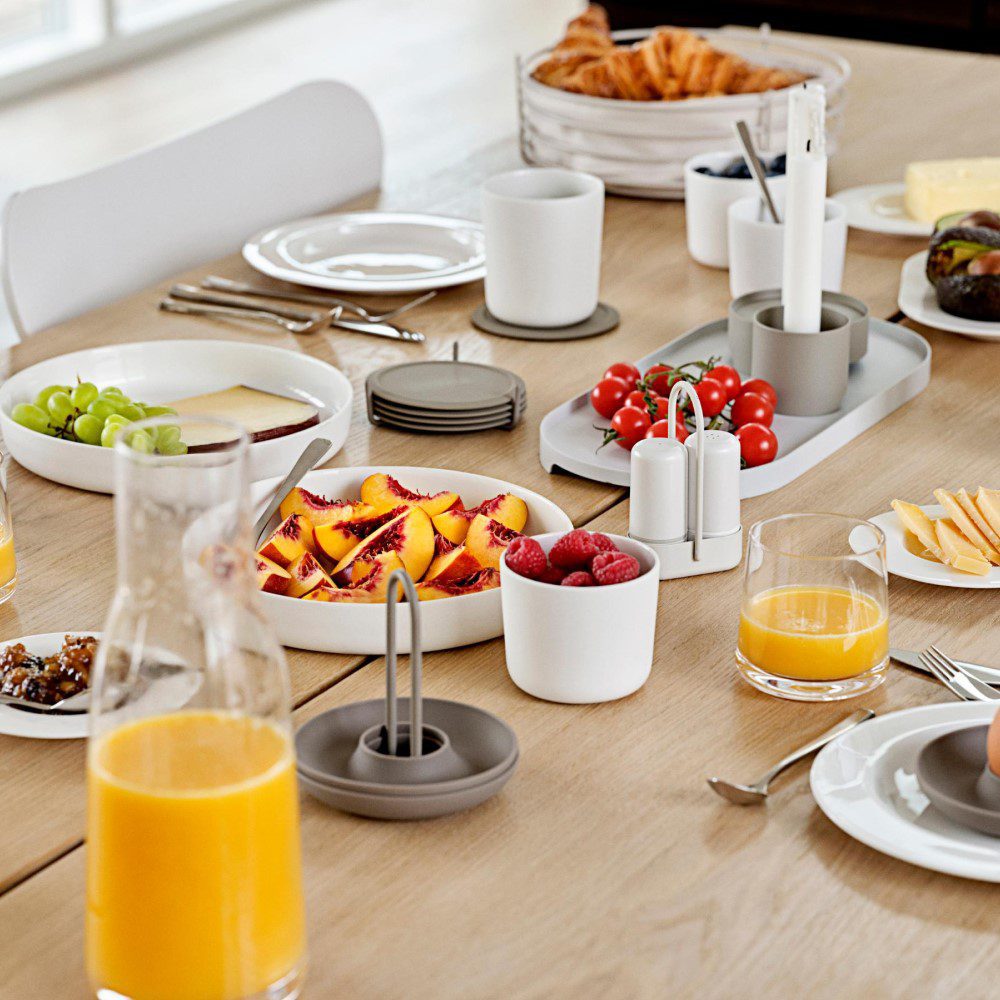 Natural light, kitchen table scene filled with food and drinks.