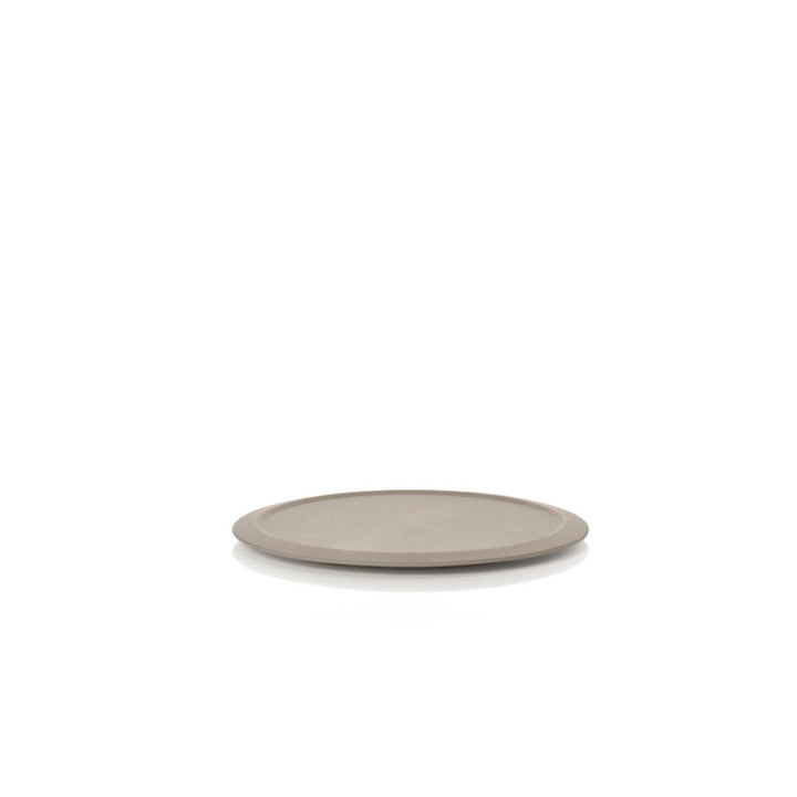 White background, studio image of a light brown, circle-shaped coaster.